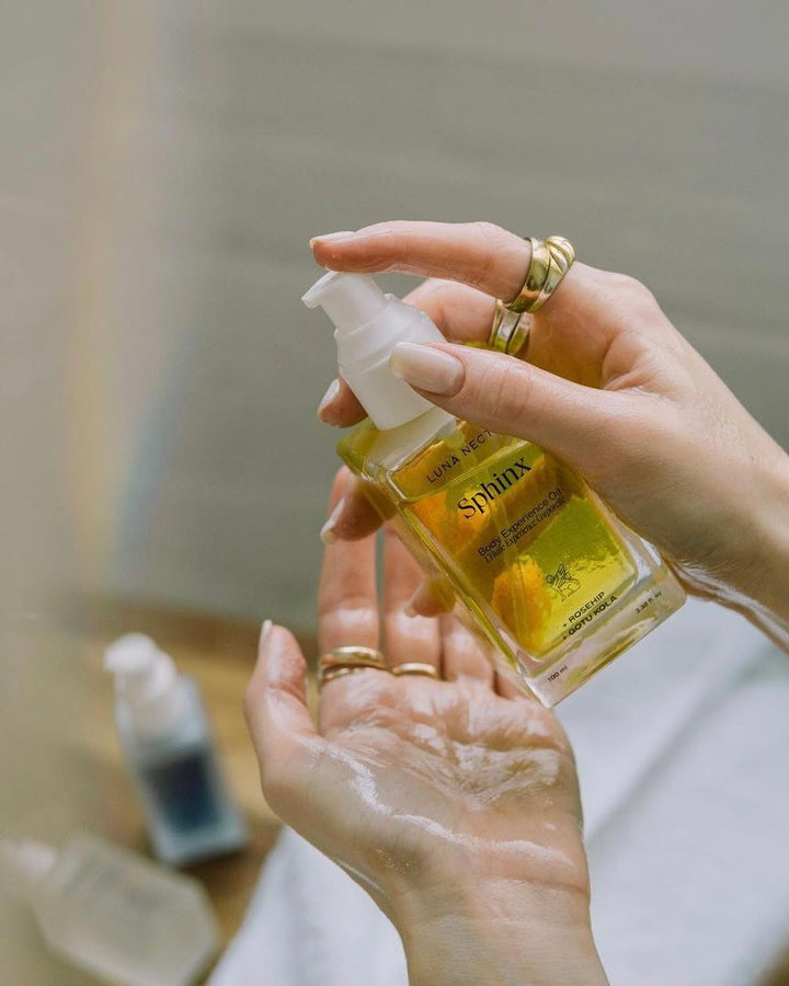 Woman holding Sphinx Body Oil with soft, hydrated hands - natural fall skincare hydration